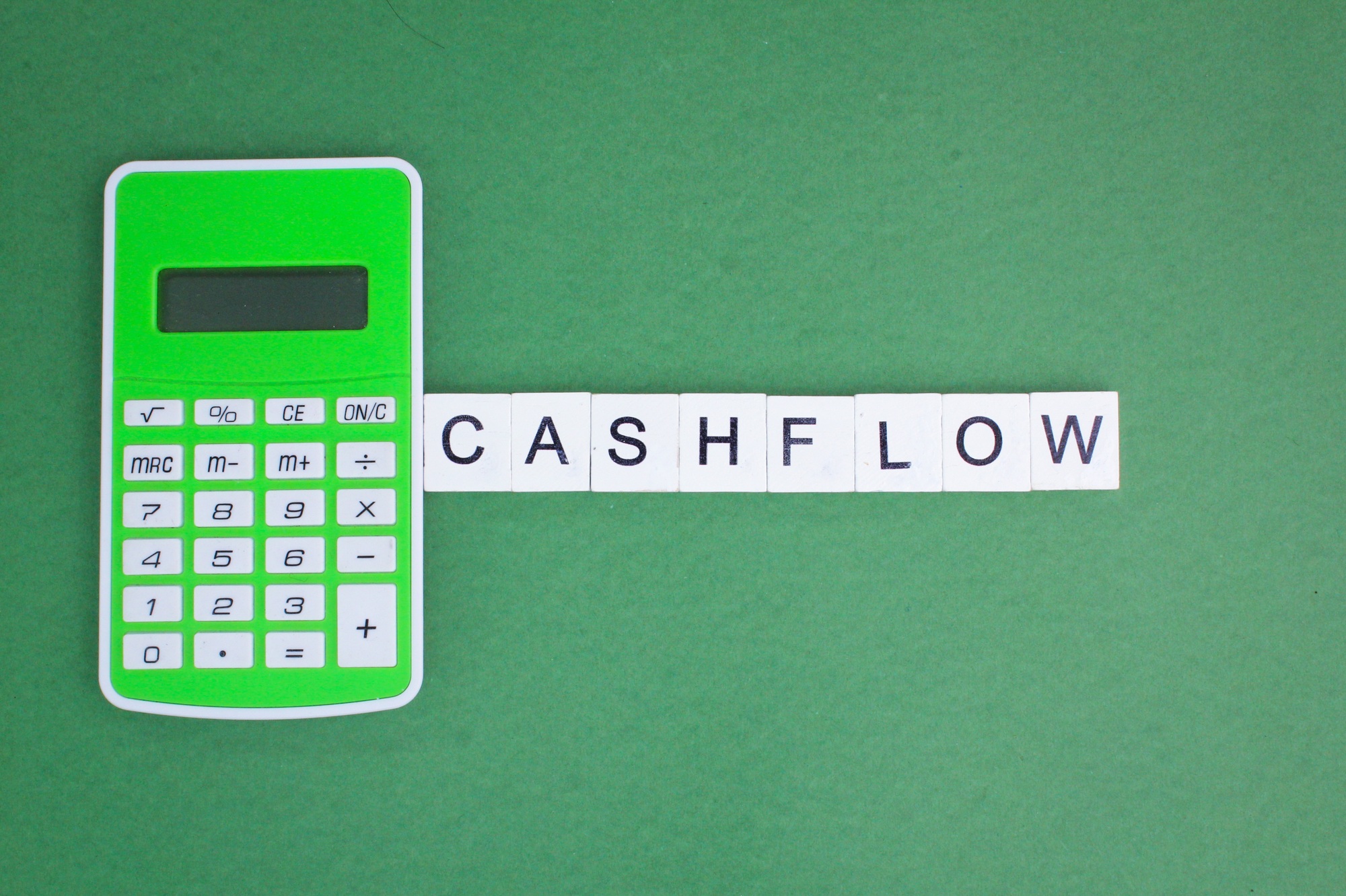 calculator, banknotes and letters of the alphabet with the word cash flow.