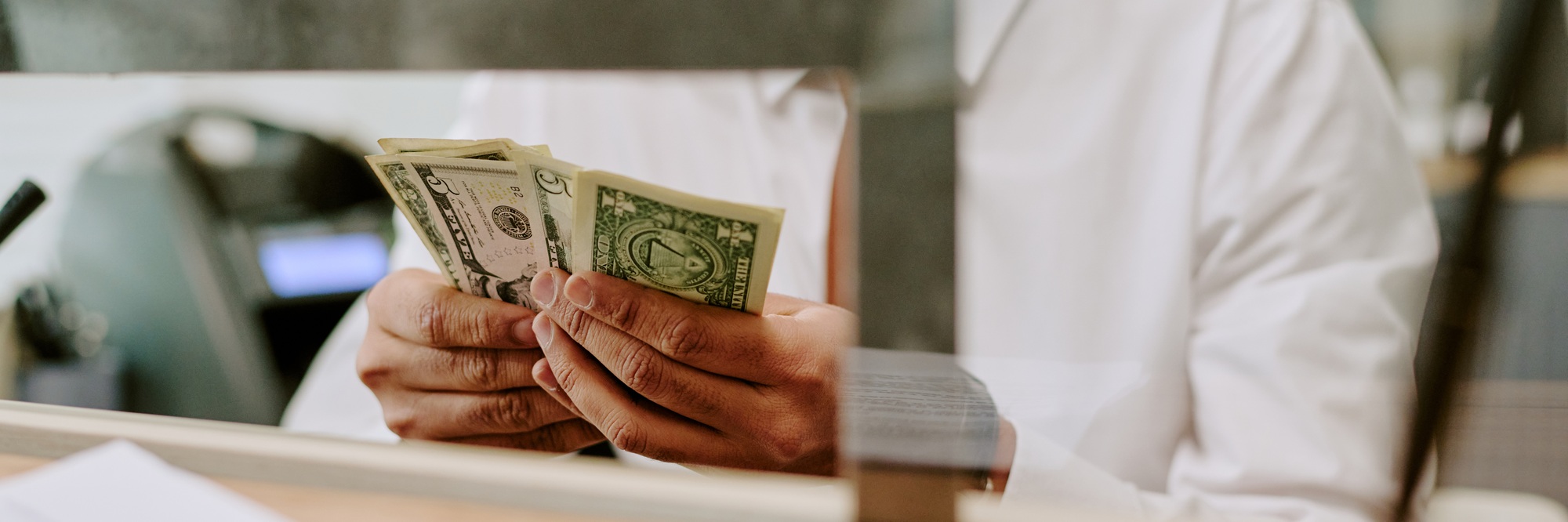 Counting Cash Behind Counter in Professional Environment