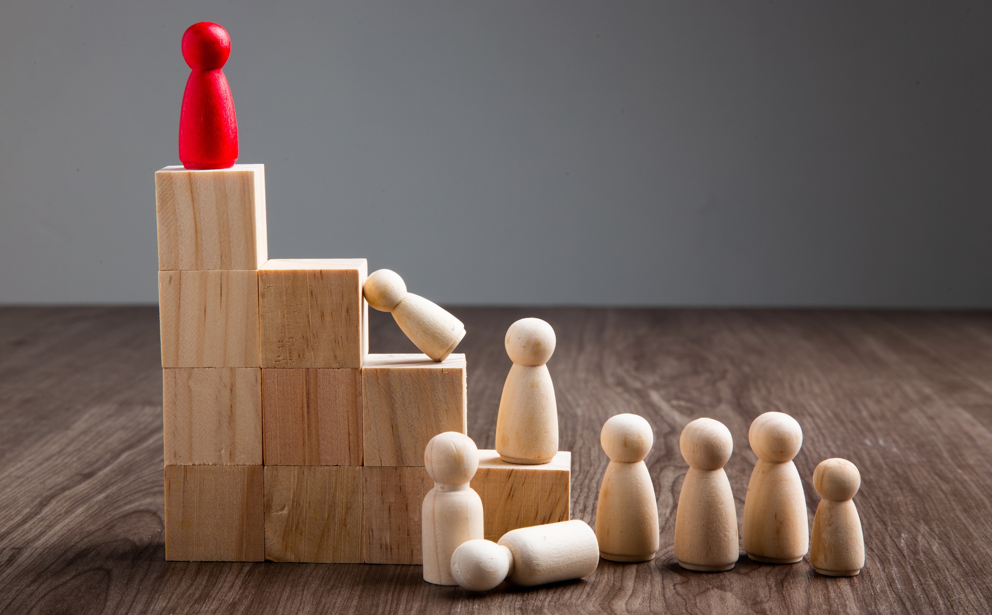 Wooden people figures on wooden background. Career growth, development and leadership