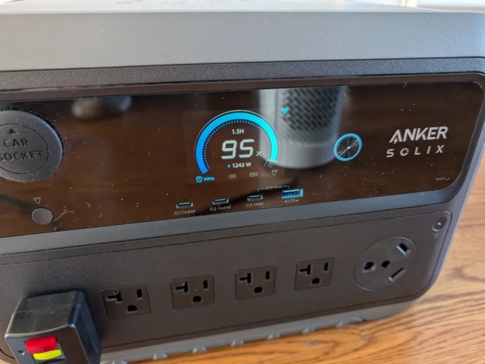 Anker Solix portable power station with a digital display showing battery percentage, power output, and various ports for charging devices.