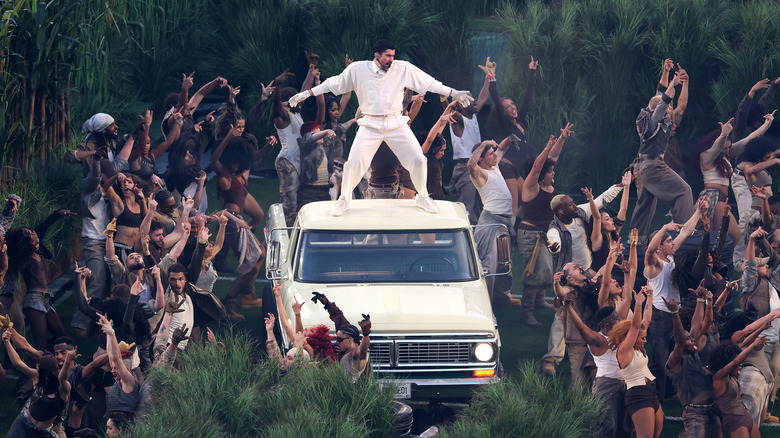 Bad Bunny performing on top of a car during Super Bowl LX